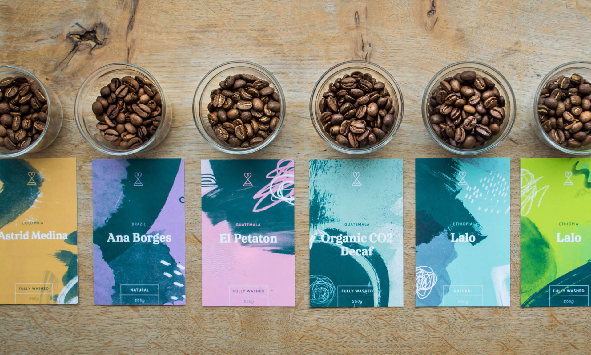 Jars of coffee beans on a table next to branded cards/labels for Passion Fruit Coffee.